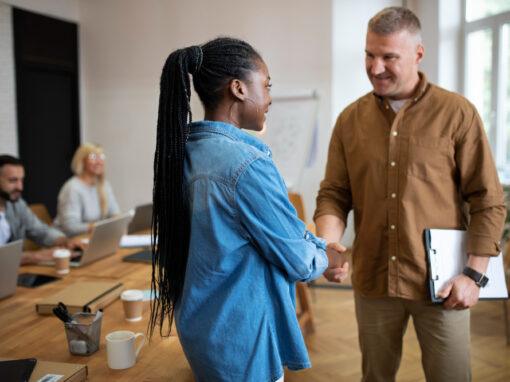 Dirigeant d'entreprise qui finalise la transmission de son entreprise avec une jeune entrepreneuse.